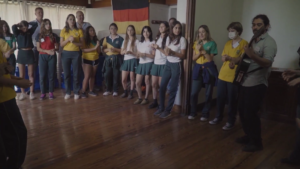 jovenes escolares reunidos aplaudiendo y cantando